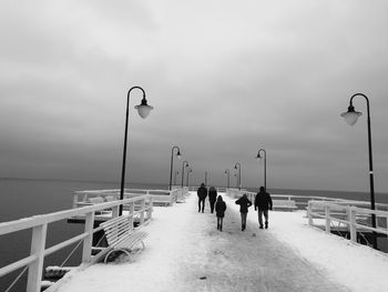 People on sea shore against sky