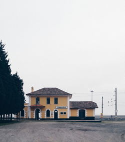 Building by road against clear sky