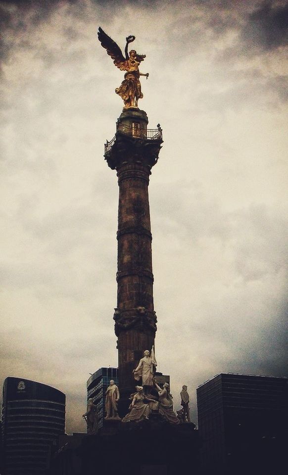 architecture, built structure, building exterior, low angle view, sky, cloud - sky, cloudy, city, cloud, sculpture, tall - high, statue, building, outdoors, day, overcast, no people, weather, tower, history