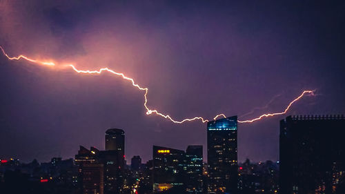 Panoramic shot of illuminated city against sky at night