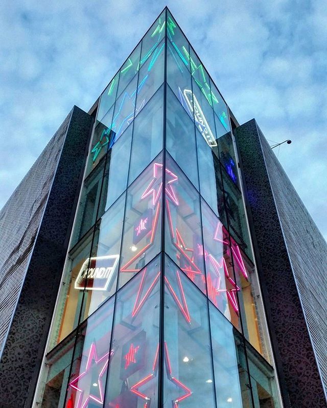 low angle view, architecture, building exterior, built structure, sky, glass - material, window, modern, building, city, office building, reflection, cloud - sky, day, cloud, no people, outdoors, multi colored, tall - high, city life