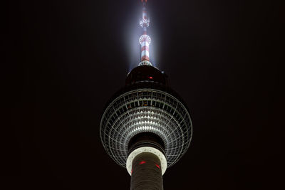 Low angle view of illuminated tower against sky at night