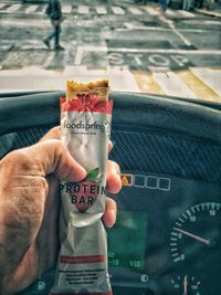 Midsection of man holding mobile phone in car