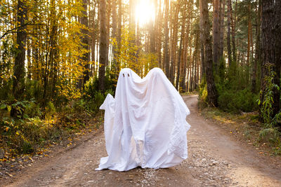 Rear view of woman standing in forest