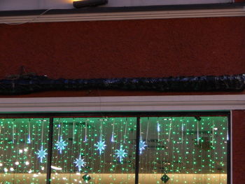 Low angle view of illuminated glass window at night