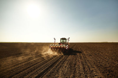 Tractor with seeder sowing crops at soybean farm