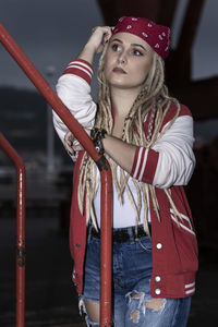 Blonde woman with dreadlocks leaning on one hand