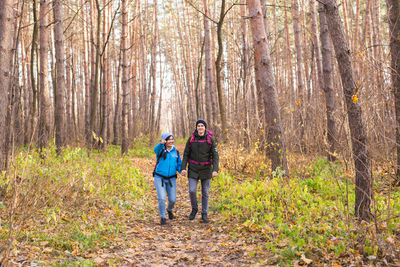 Full length of couple standing in forest