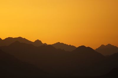 Silhouette mountains against clear sky during sunset