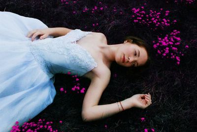 High angle view of woman in blue dress sleeping on grass