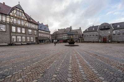 Street by buildings against sky in city