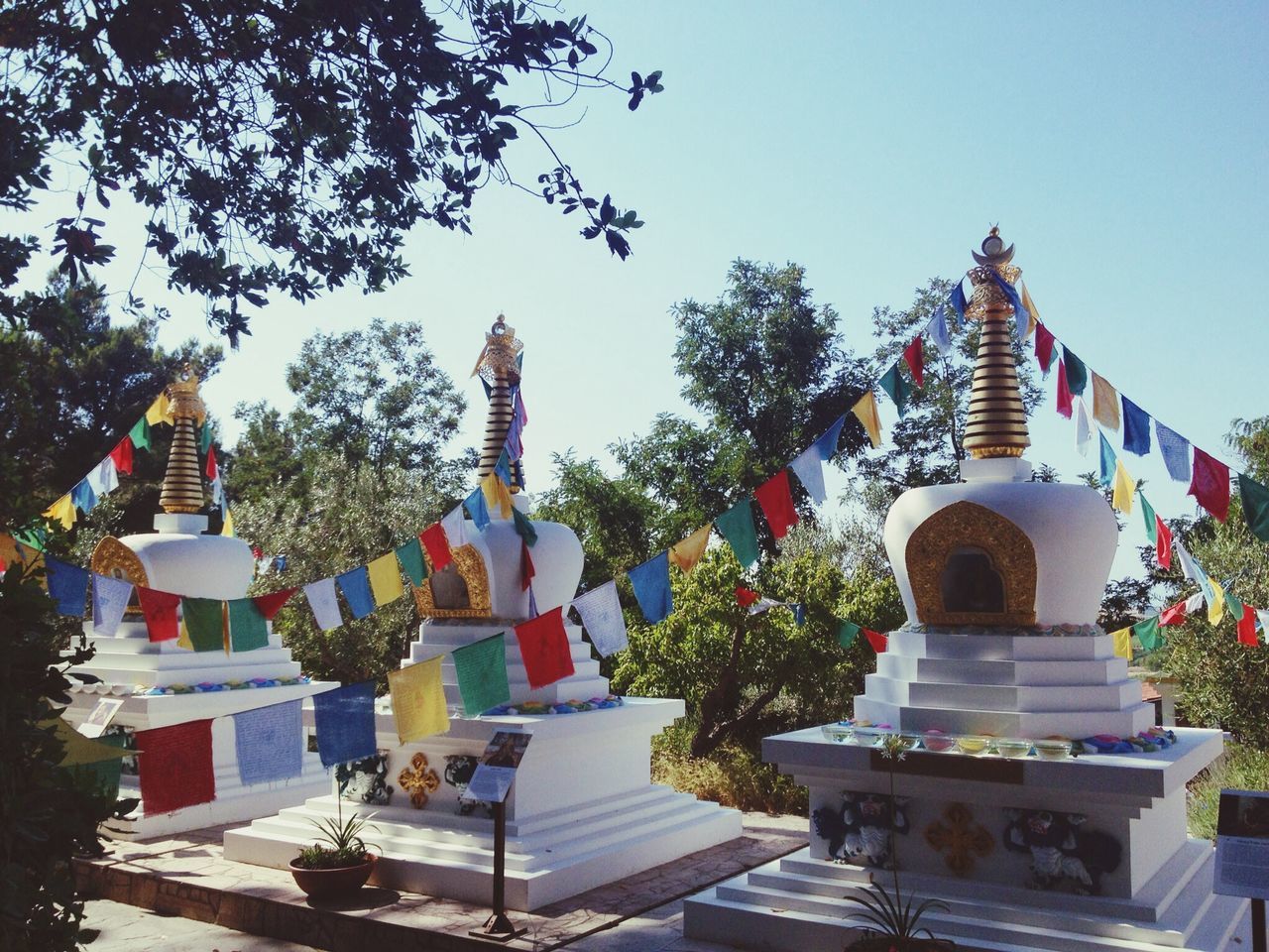 architecture, built structure, building exterior, religion, sculpture, statue, art and craft, art, tree, place of worship, spirituality, low angle view, human representation, temple - building, creativity, clear sky, famous place, travel destinations