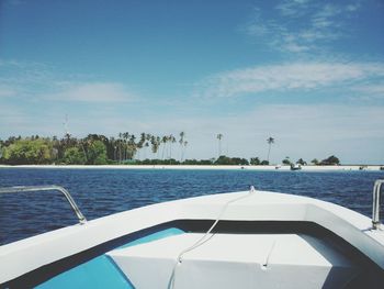 Boat sailing in sea against blue sky