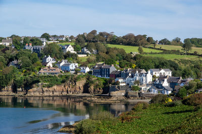 Scenic view of river amidst buildings against sky