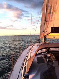 Sailboat sailing on sea against sky during sunset