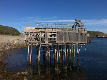 Metallic structure by sea against sky