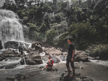 Man surfing on waterfall in forest