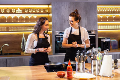 Side view of female friends working at table