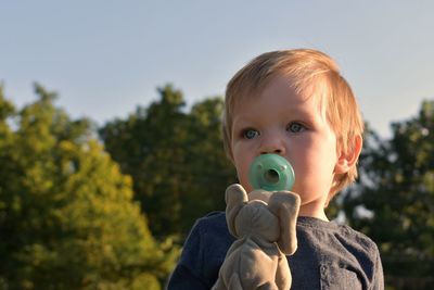 Close-up portrait of boy against sky