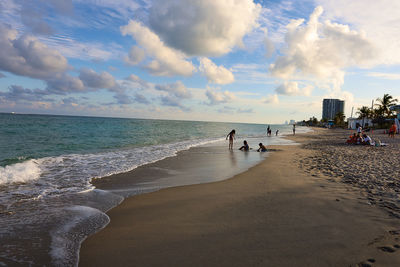 Panoramic view of people on beach against sky