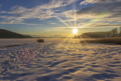 Scenic view of snow field against sky during sunset