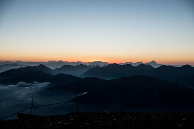 Scenic view of silhouette mountains against sky at sunset