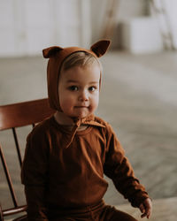 Toddler baby boy in funny costume with ears sitting looking at the camera