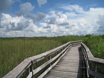 Footbridge over field against sky