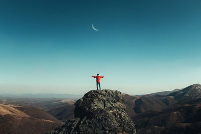 Man looking at mountain against sky