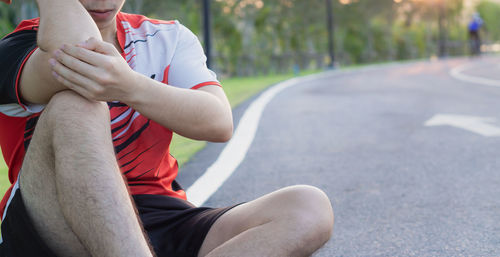 Low section of man sitting on road