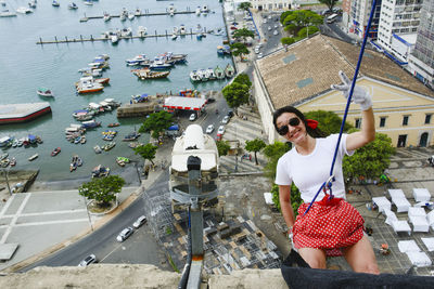 Caucasian woman wearing hero costume descending a tall building in rappel. salvador bahia brazil.