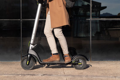 Crop view of man riding electric scooter as an alternative and eco friendly transportation