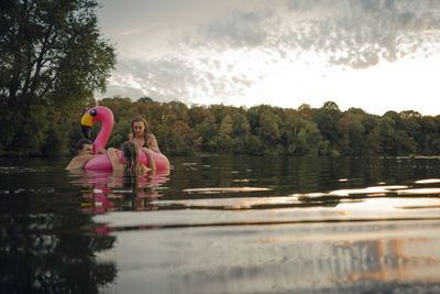 Woman swimming in lake against trees