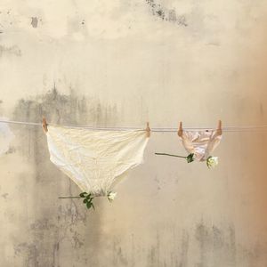 Panties with flowers drying against wall