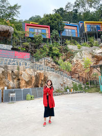 Full length portrait of woman standing against trees