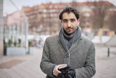 Elegant man with smartphone on street