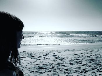 Side view of woman on beach against clear sky