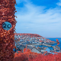 Aerial view of townscape by sea against sky