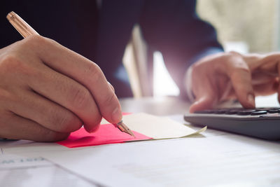 Midsection of man writing on paper