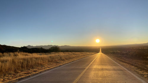 Road amidst landscape against sky during sunset