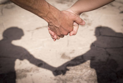 Cropped image of couple holding hands outdoors