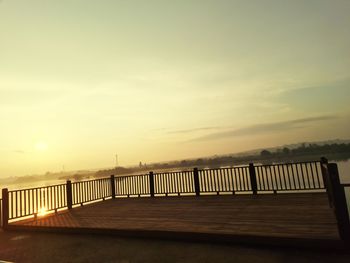 Bridge over sea against sky during sunset