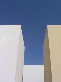 Low angle view of buildings against clear blue sky