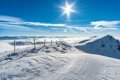 Scenic view of snowcapped mountains against blue sky