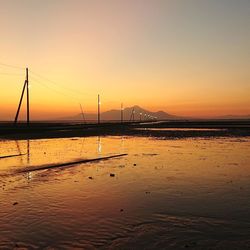 Bridge over sea against sky during sunset