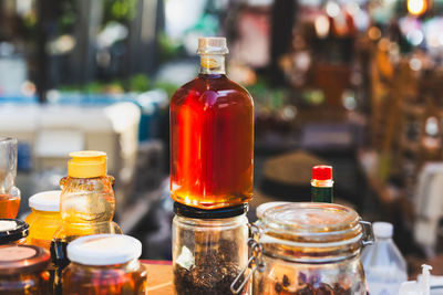 Honey in bottles with display for sale in store.