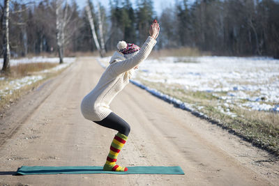 Young attractive woman practicing yoga on the rural road.outdoor activity. practice yoga asana. 