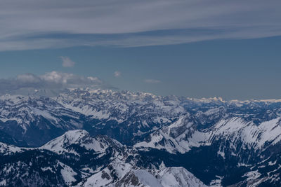 Aerial view of snowcapped mountains against sky