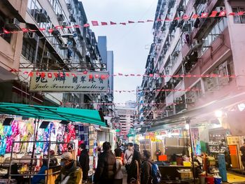 People on street amidst buildings in city