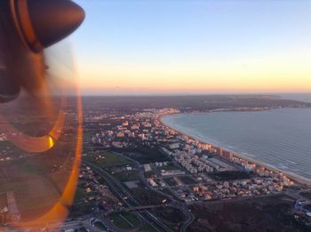 Aerial view of city and buildings against sky during sunset